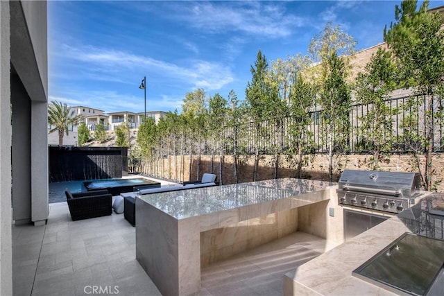 view of patio featuring area for grilling, fence, and a grill