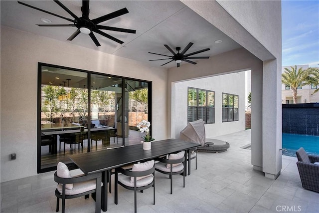 view of patio featuring outdoor dining area, a ceiling fan, and an outdoor pool