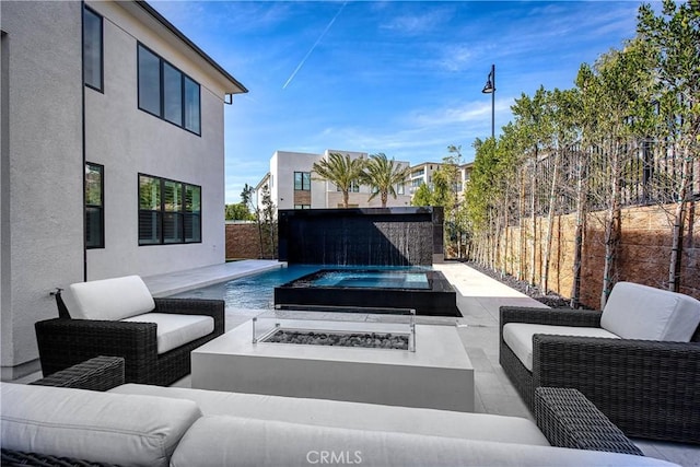 view of patio / terrace with a fenced backyard, a fenced in pool, and an outdoor living space with a fire pit