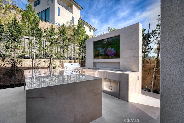 view of patio featuring a sink, area for grilling, and fence