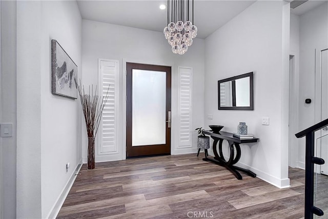 foyer with an inviting chandelier, wood finished floors, and baseboards