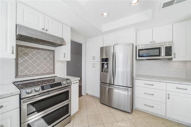 kitchen with a raised ceiling, visible vents, appliances with stainless steel finishes, white cabinetry, and under cabinet range hood