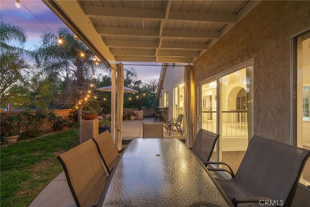 patio terrace at dusk with fence and outdoor dining space