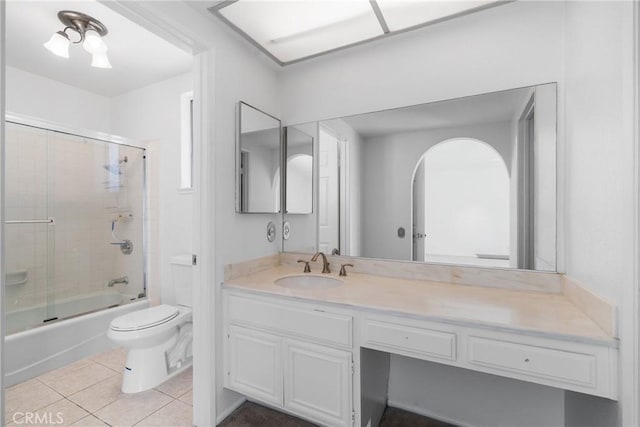 full bathroom with tile patterned flooring, combined bath / shower with glass door, vanity, and toilet