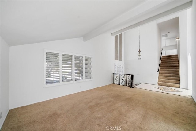 unfurnished room with carpet floors, stairway, and lofted ceiling with beams