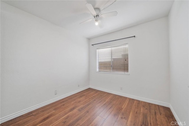 empty room with a ceiling fan, baseboards, and wood finished floors