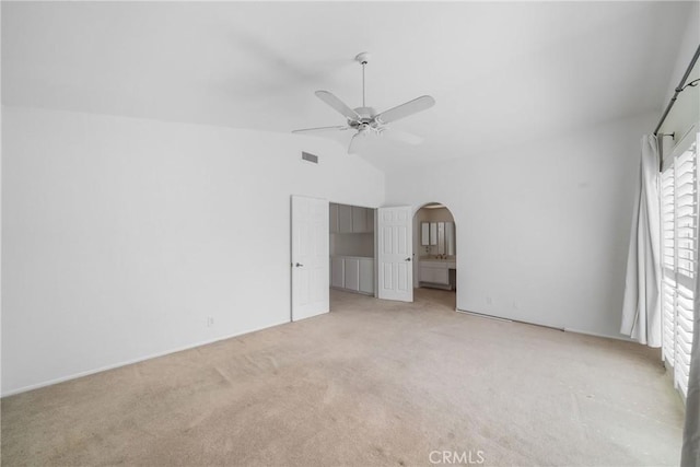 unfurnished bedroom with light carpet, visible vents, arched walkways, a ceiling fan, and high vaulted ceiling