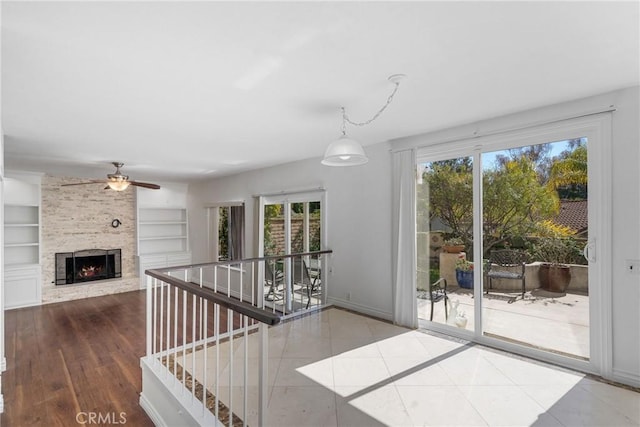 interior space featuring a healthy amount of sunlight, a large fireplace, built in features, and tile patterned floors