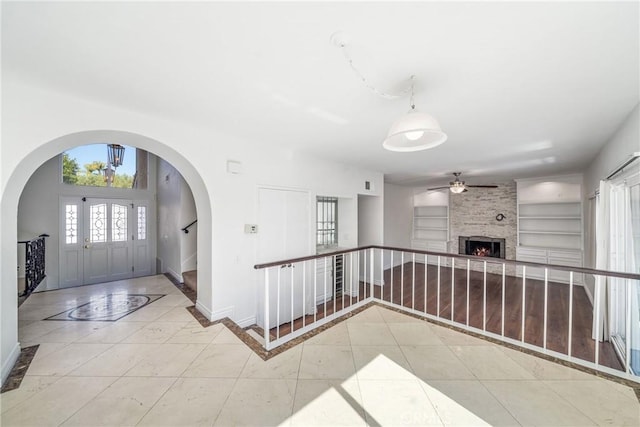 tiled entryway featuring a large fireplace and baseboards