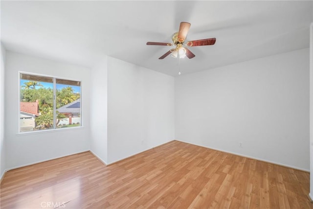 spare room with light wood-style floors and a ceiling fan