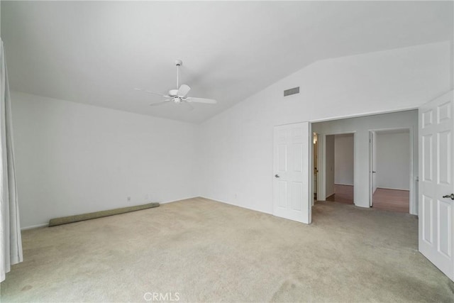 spare room with lofted ceiling, light carpet, visible vents, and a ceiling fan