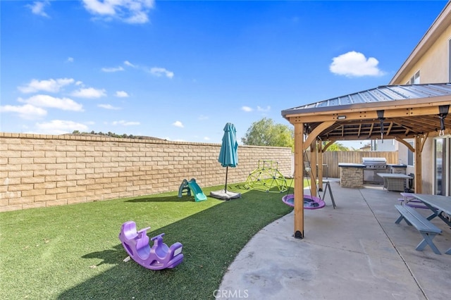 view of yard with a gazebo, a patio area, a fenced backyard, and an outdoor kitchen