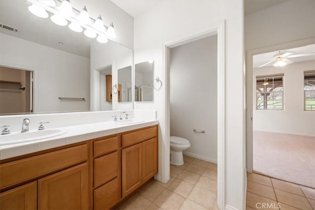 bathroom featuring toilet, visible vents, a sink, and tile patterned floors