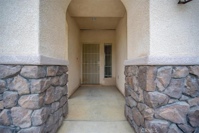 entrance to property with stucco siding