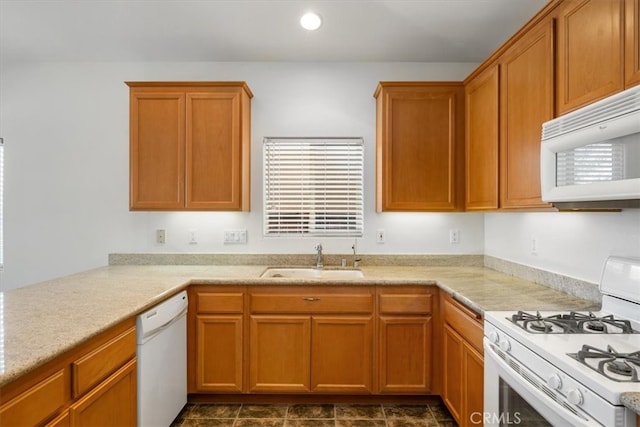 kitchen with light countertops, white appliances, a sink, and recessed lighting