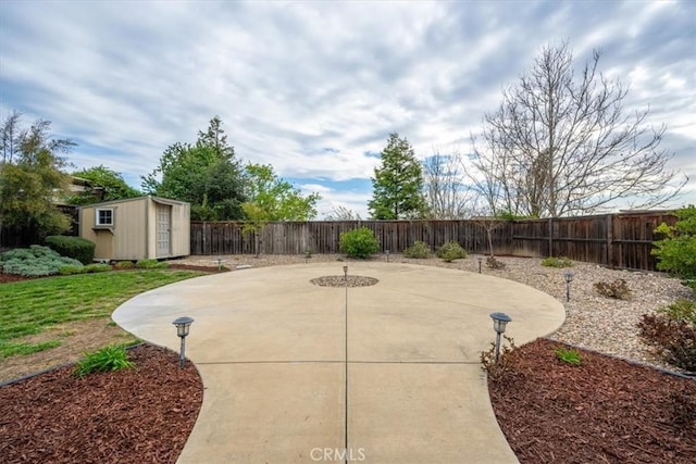 view of patio featuring a storage shed, a fenced backyard, and an outdoor structure