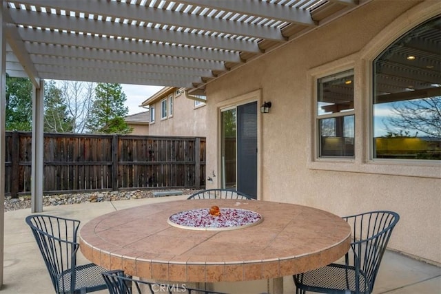 view of patio featuring outdoor dining area, fence, and a pergola