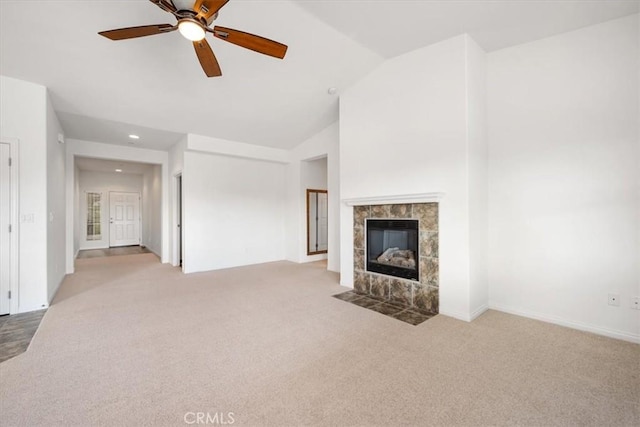 unfurnished living room featuring carpet, lofted ceiling, recessed lighting, a ceiling fan, and a tile fireplace