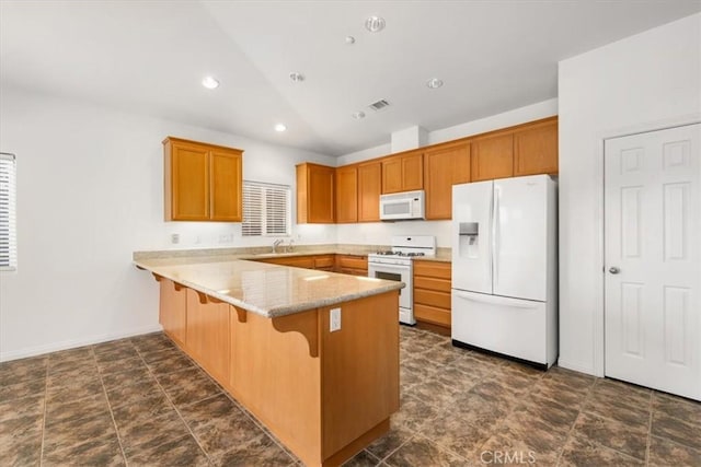 kitchen featuring white appliances, visible vents, a breakfast bar area, a peninsula, and recessed lighting