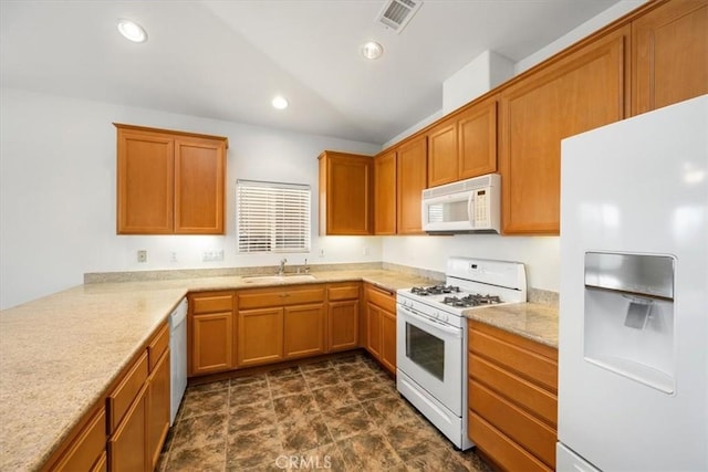 kitchen featuring recessed lighting, white appliances, a sink, visible vents, and brown cabinets