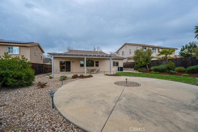 back of property featuring a fenced backyard and a patio