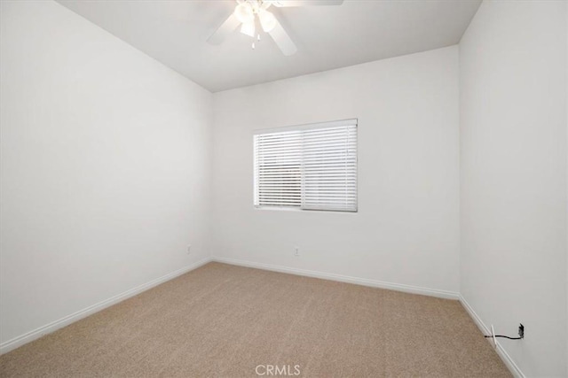 empty room featuring light carpet, ceiling fan, and baseboards