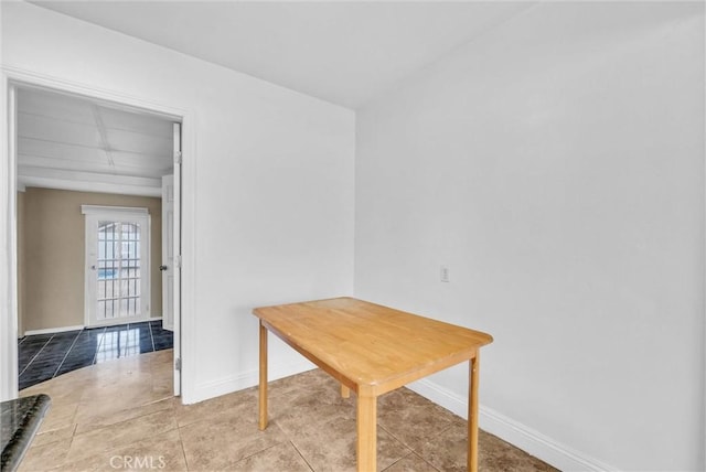 dining space featuring light tile patterned flooring and baseboards