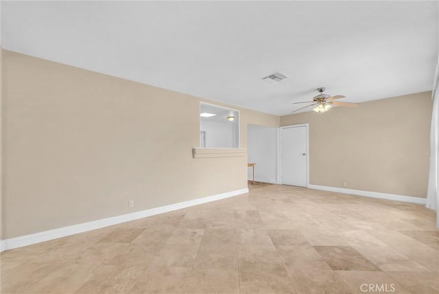 spare room featuring a ceiling fan, visible vents, and baseboards