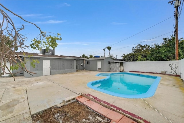 view of swimming pool with an outbuilding, a patio, a fenced backyard, and a fenced in pool