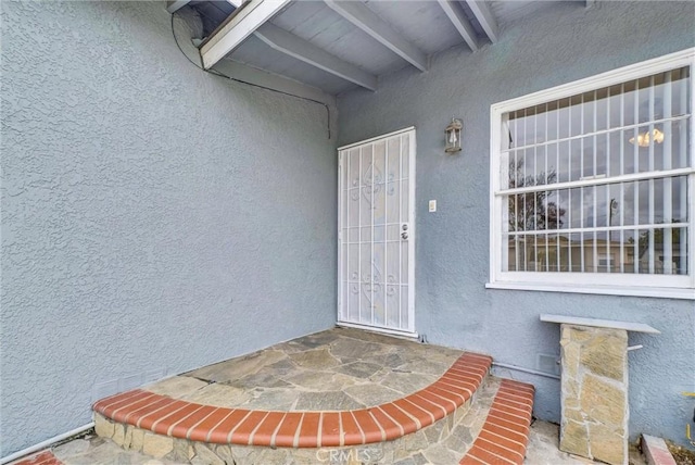 entrance to property featuring stucco siding