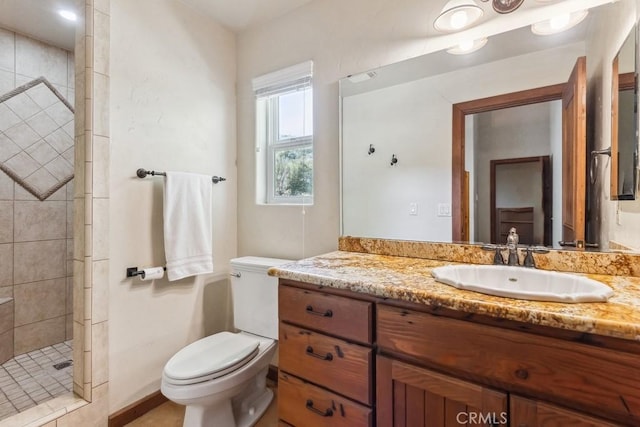 full bath with tiled shower, vanity, and toilet