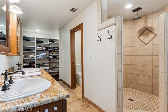 bathroom with toilet, a stall shower, visible vents, and a sink