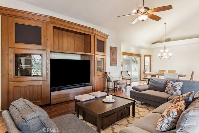 living area featuring lofted ceiling, light wood finished floors, and ceiling fan with notable chandelier