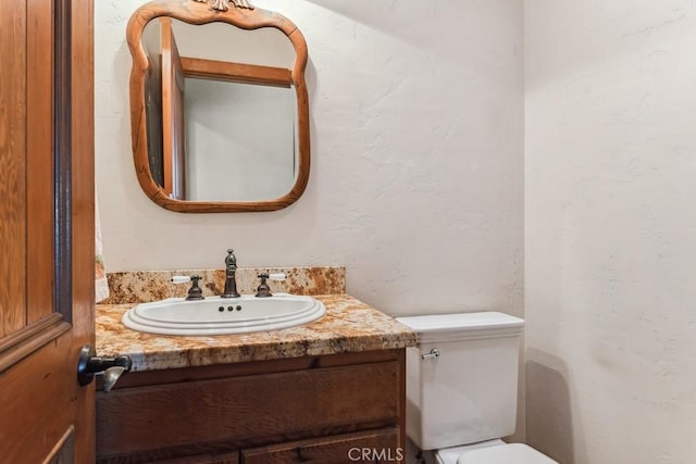 half bathroom with toilet and vanity