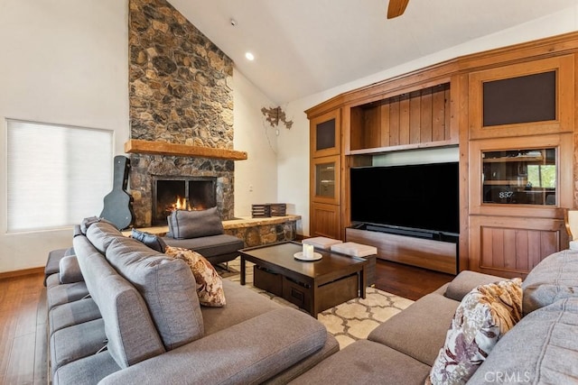 living area with a healthy amount of sunlight, a fireplace, a ceiling fan, and wood finished floors