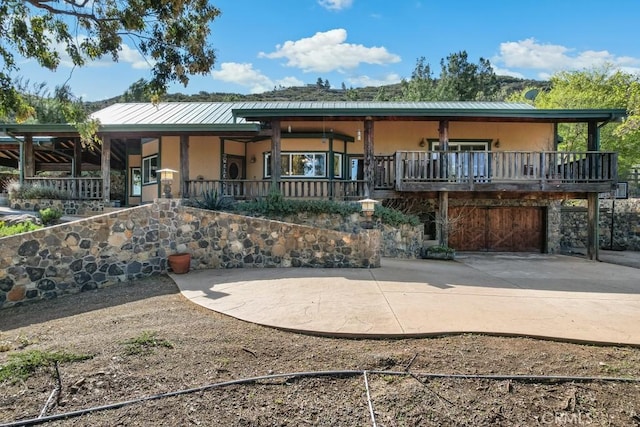 view of front of house with stairs, metal roof, and stucco siding