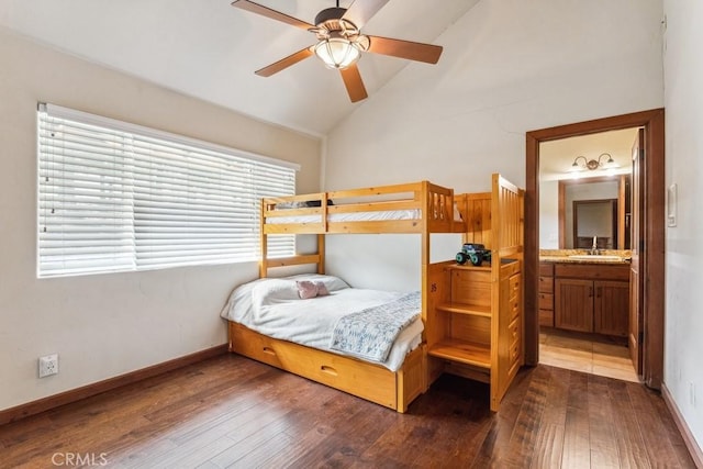 bedroom featuring lofted ceiling, a sink, dark wood finished floors, and baseboards