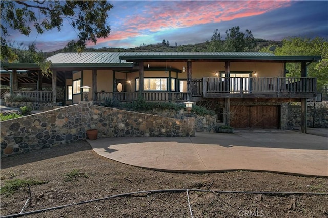 view of front of home featuring stairway, metal roof, and stucco siding