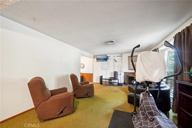 living area with carpet, visible vents, a textured ceiling, and baseboards