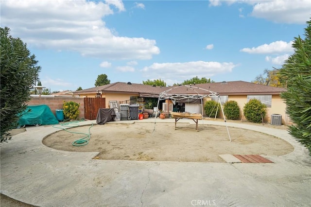 ranch-style home with a patio, central AC unit, fence, and stucco siding