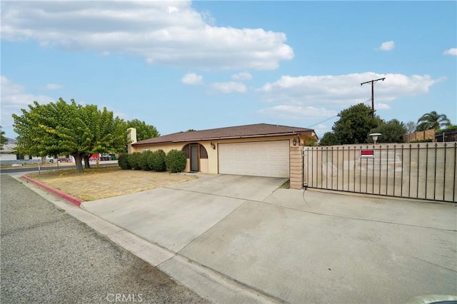 view of front of home with a garage, concrete driveway, and fence