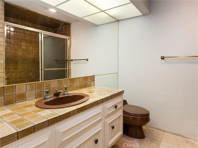 full bathroom featuring toilet, a shower stall, backsplash, and vanity