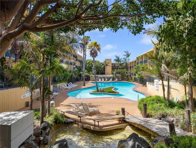 pool featuring fence and a patio