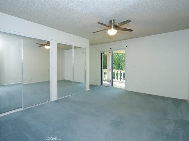 carpeted empty room with ceiling fan and a textured ceiling