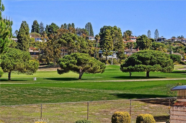 view of home's community featuring a lawn and fence