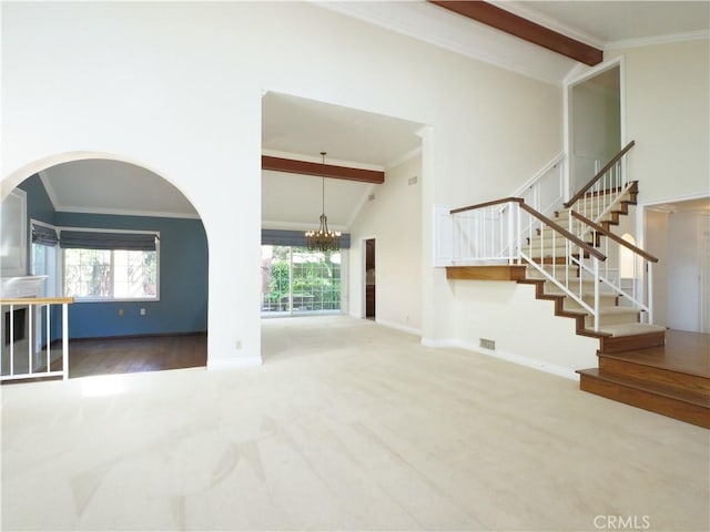 unfurnished living room featuring high vaulted ceiling, ornamental molding, baseboards, and stairs