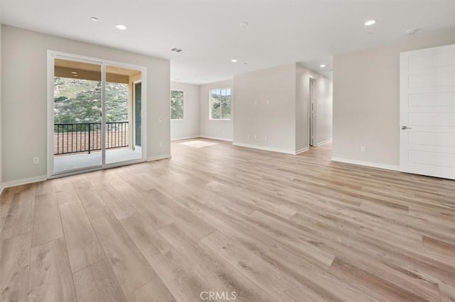 empty room with recessed lighting, baseboards, visible vents, and light wood finished floors