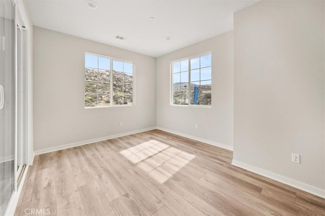 unfurnished bedroom with baseboards, visible vents, and light wood finished floors