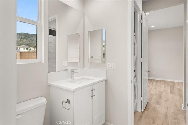 bathroom featuring toilet, recessed lighting, wood finished floors, vanity, and baseboards