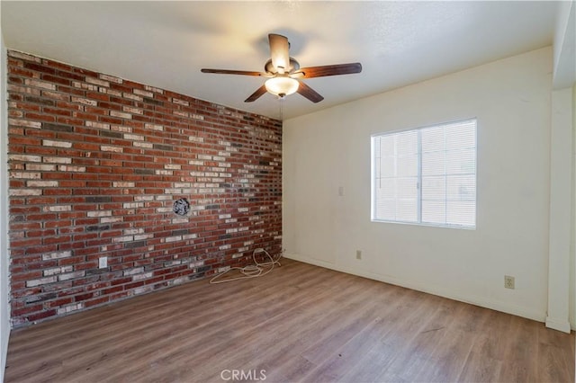 6125 Ridgeview Ave, Jurupa Valley, CA 91752 - spare room with wood finished floors, a ceiling fan, and brick wall